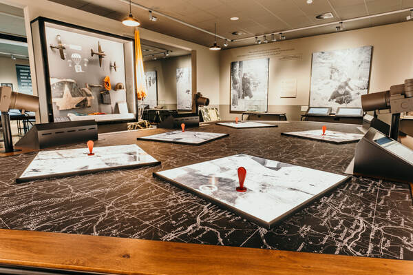 Museumzaal met vitrines en kaarten