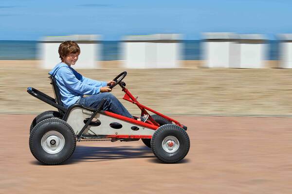 Jongen rijdt met een skelter over het strand
