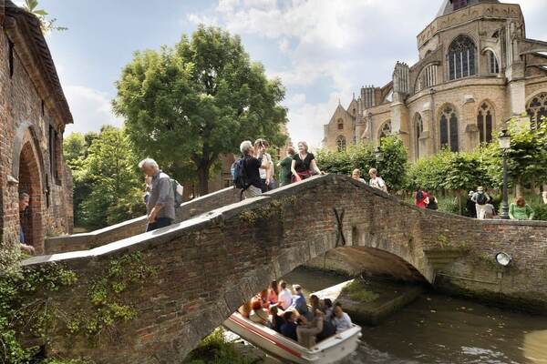 Wandelaars op een brug over de reien