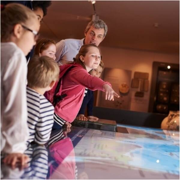 Visiteurs autour d'une table interactive