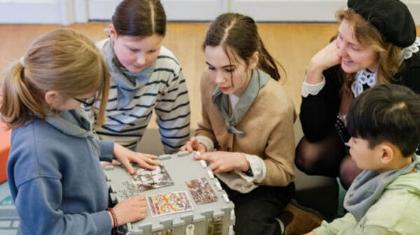 Bezoekers rond een tafel met museumstukken