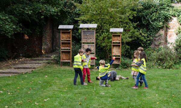 Des enfants près d'hôtels à insectes dans l'herbe