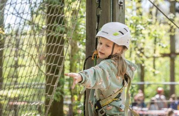 Meisje met helm op een touwenparcours