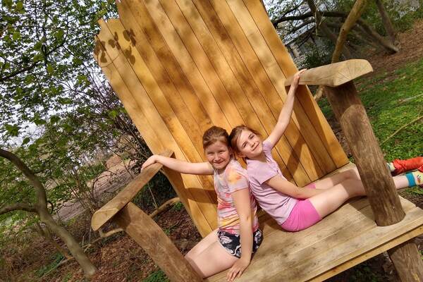 Deux filles sur une grande chaise en bois