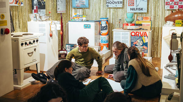 Bezoekers in een zaal met oude huishoudtoestellen