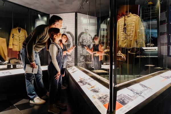 Bezoekers bij een vitrine met uniformen