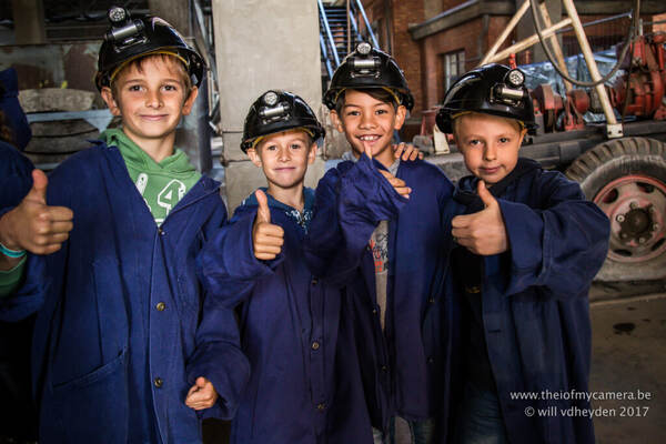Kinderen in mijnwerkerskledij met helm