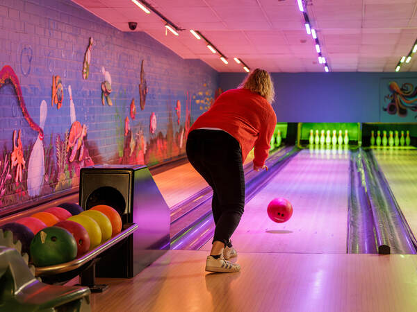 Speler werpt een bal op de bowlingbaan