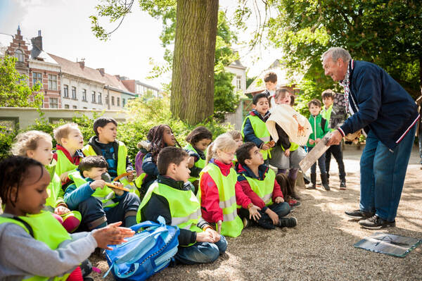 Des enfants en gilet fluo écoutent les explications