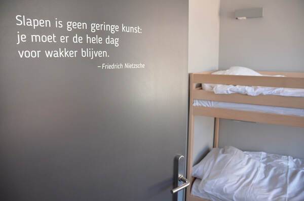 Stapelbed onder een muurcitaat
