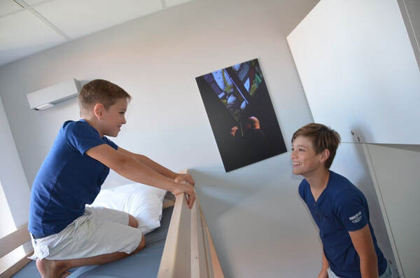 Twee jongens maken hun bed op