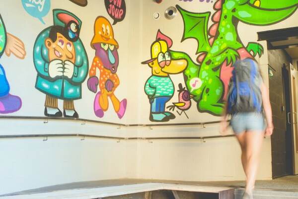 Muurschildering met stripfiguren in de gang