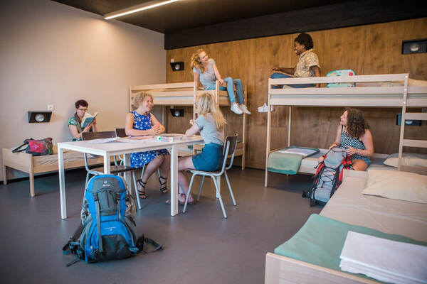 Kinderen met rugzakken bij de stapelbedden