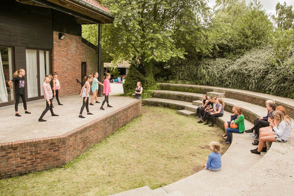 Des enfants sur les gradins en herbe du jardin