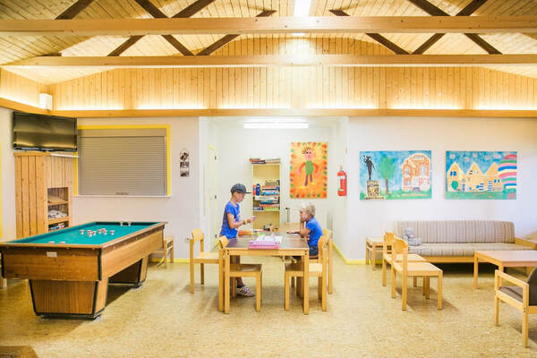 Un enfant joue au billard dans la salle de jeux