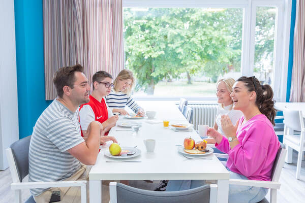 Une famille prend le petit-déjeuner près de la fenêtre
