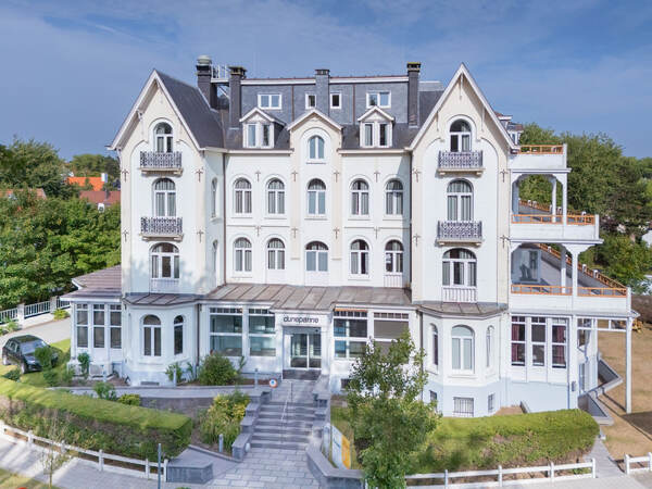 Villa blanche à tourelles dans la verdure