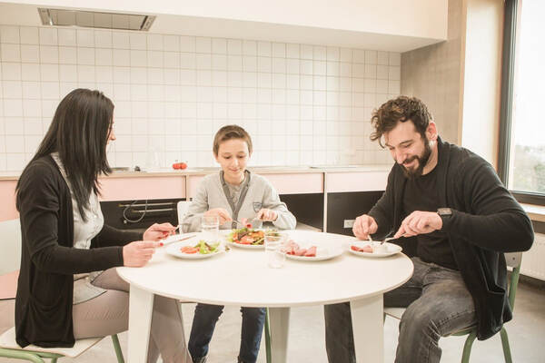 Drie gasten eten aan een ronde tafel