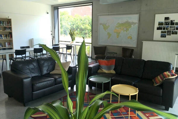 Lounge met zwarte zetel en wereldkaart