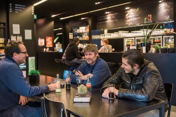 Gasten met een drankje aan de bar