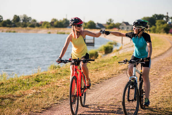 Twee fietsers op een pad langs het water