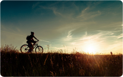 Silhouet van een fietser bij zonsondergang